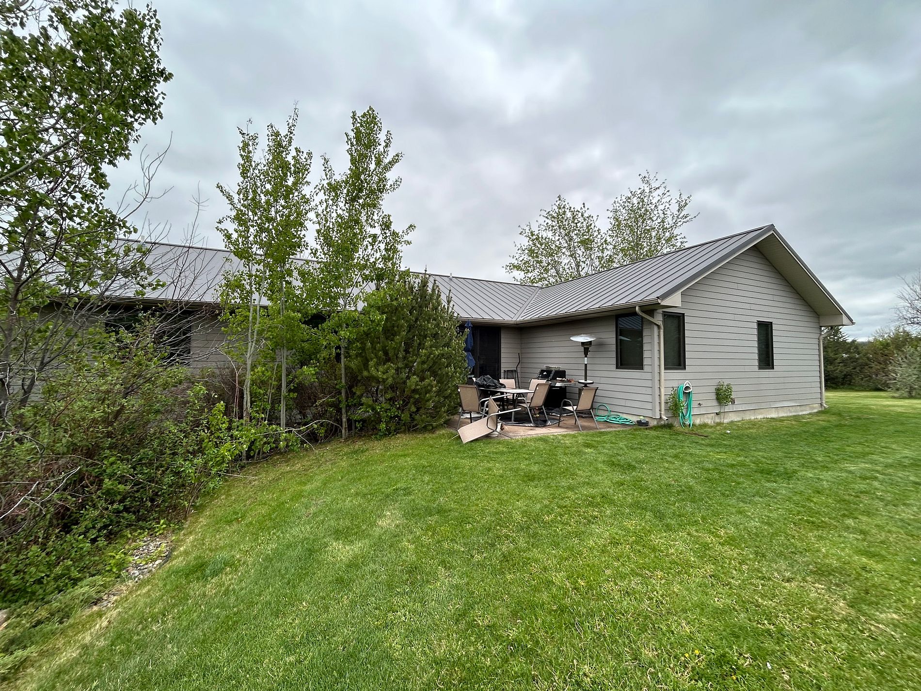 Single-story home with a low-profile gray metal roof in open country