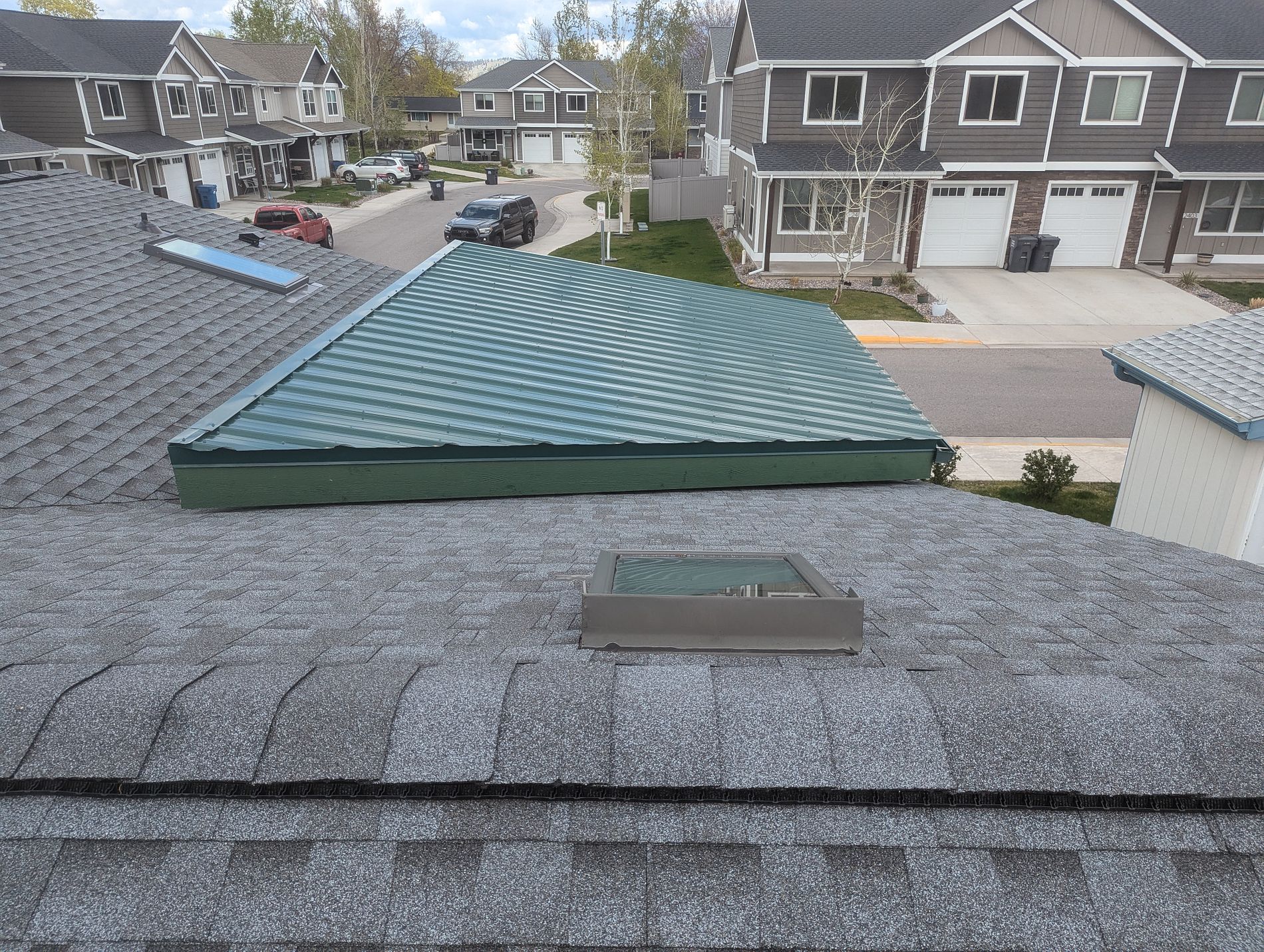 A roof deck covered with synthetic underlayment around a skylight, ready for the new roof
