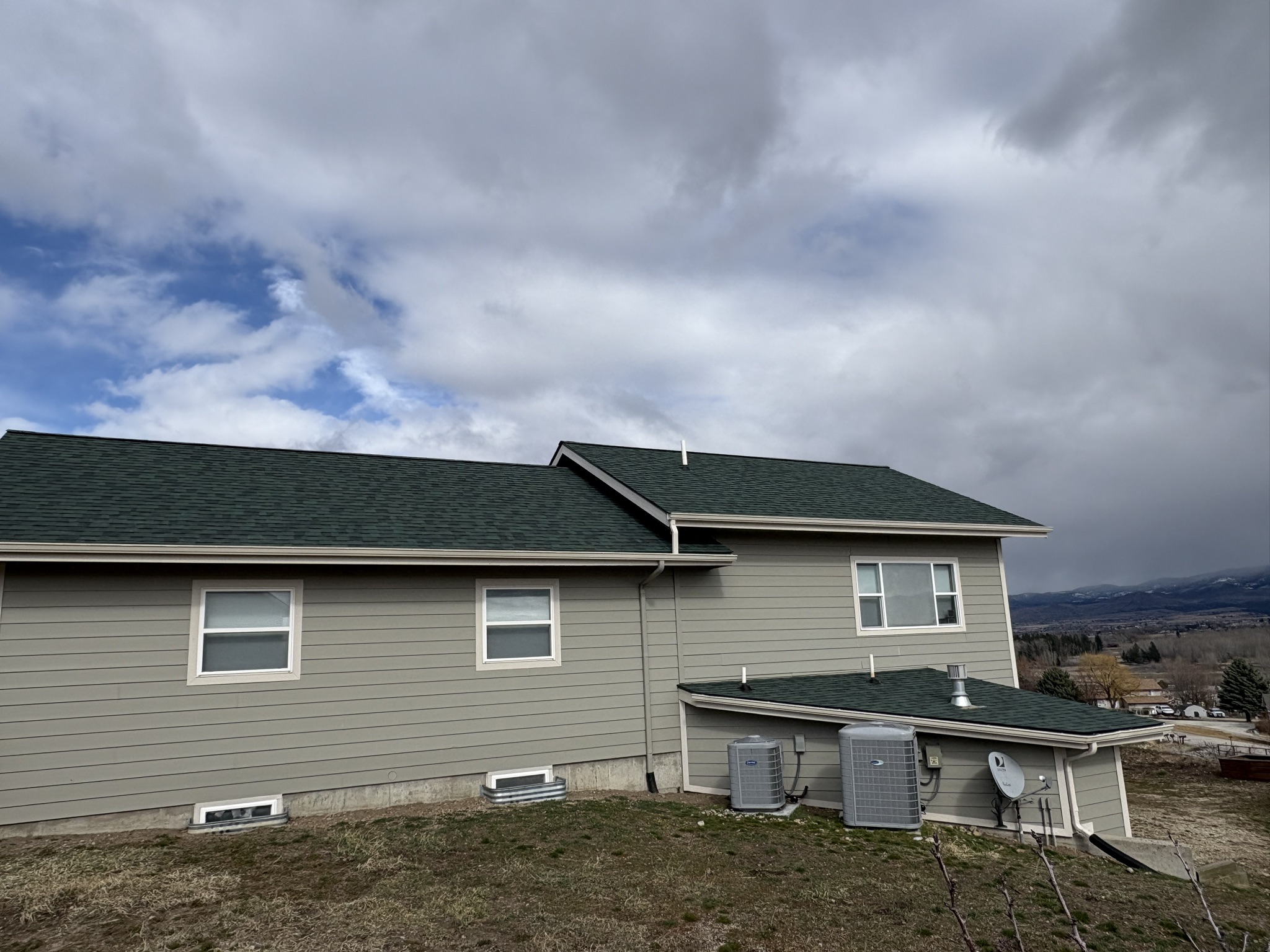 Finished residential roofing project with mountains beyond in south-central Montana