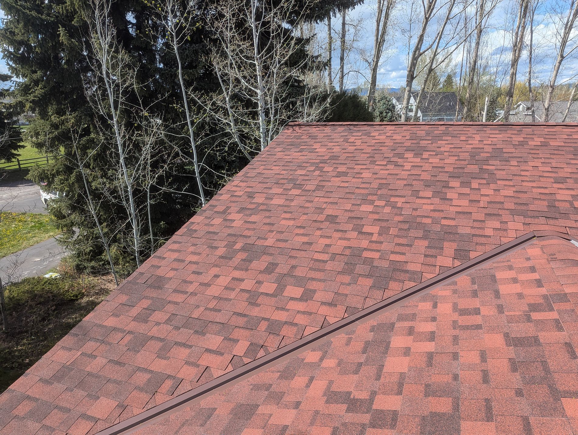 Close-up of a red-blend architectural asphalt shingle roof on a home.