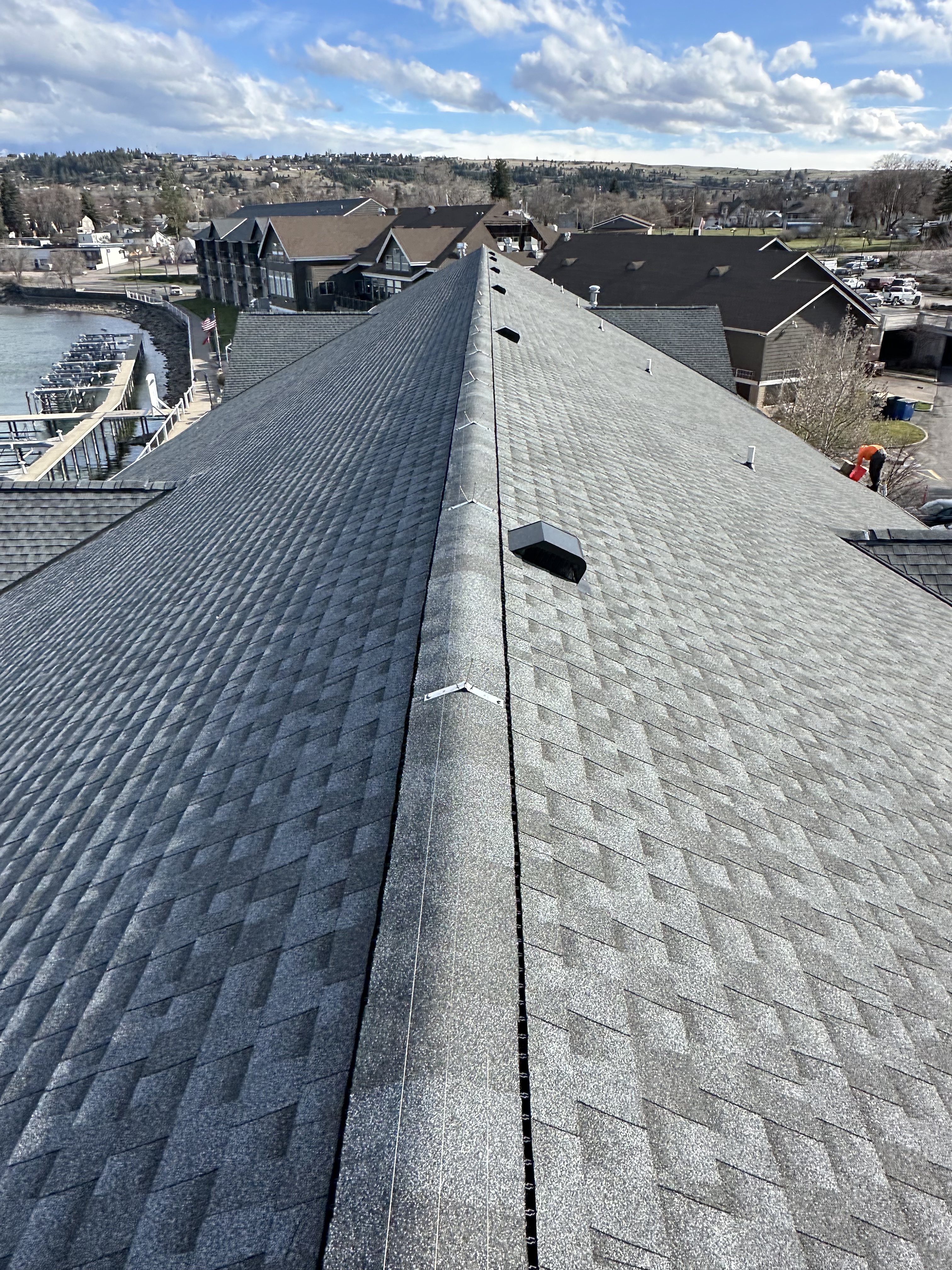 Clean ridge lines on a freshly shingled charcoal roof from above