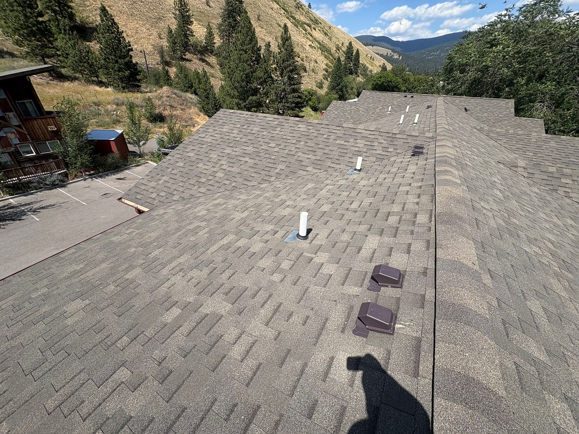 A shingle roof with a mountain backdrop